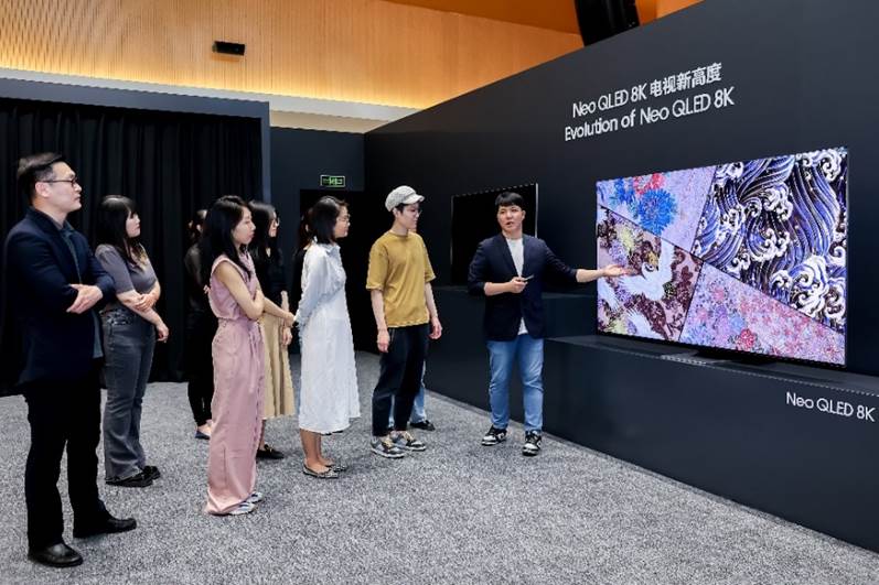 A group of people standing in front of a screen

Description automatically generated with medium confidence